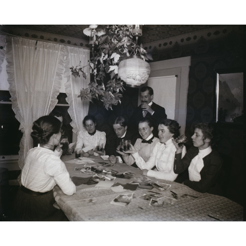 Orville Wright And Group Around A Table, Looking At Photographs, During A Party At 7 Hawthorn...