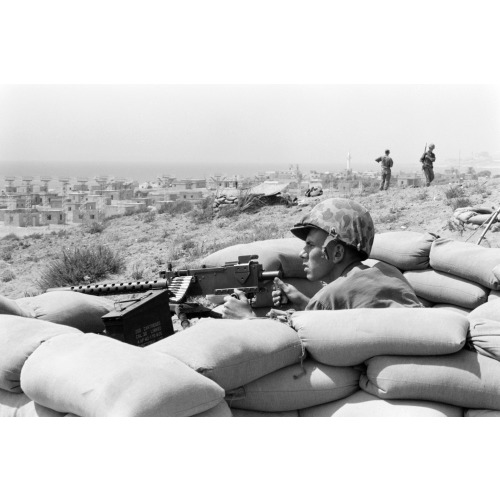 U.S. Marine Sits In A Foxhole And Points A Machine Gun Towards Beirut, Lebanon, In The Distance...