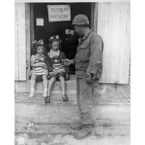 Sgt. Walter P. Goworek, Jersey City, New Jersey, Treats Two Little French Lasses With Some G.I...