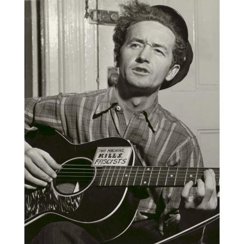Woody Guthrie, Facing Slightly Left, Holding Guitar, 1943